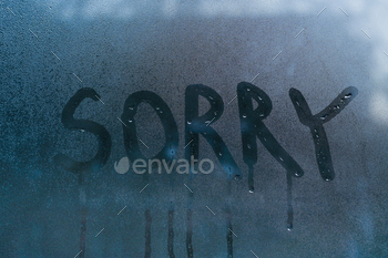 The word sorry on the wet glass.concept