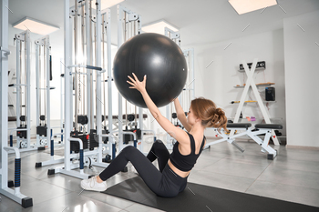Woman performs exercises with a fitball
