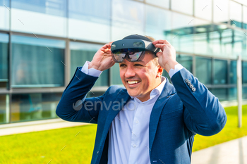 Businessman putting on virtual reality headset outdoors
