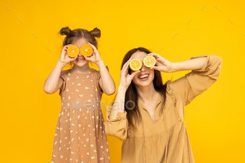 Mother and daughter are playing, on a yellow background.