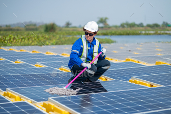Worker Cleaning Solar Panels at Renewable Energy Farm