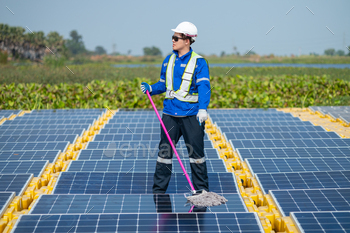 Worker Cleaning Solar Panels at Renewable Energy Farm