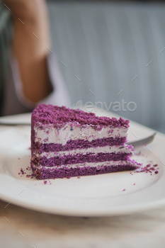 cutting A piece of purple velvet cake with cream