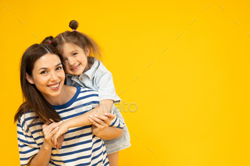 Mother and daughter are playing, on a yellow background.