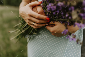 holding a bouquet of lilac purple flower