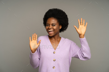 Positive black woman smiling have fun, showing palms bumping into invisible wall like mime in studio
