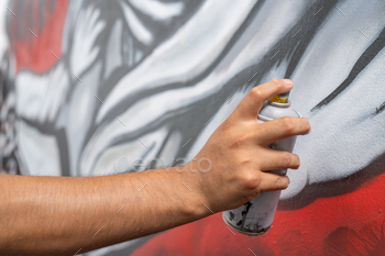 Young man painting graffiti with spray paint