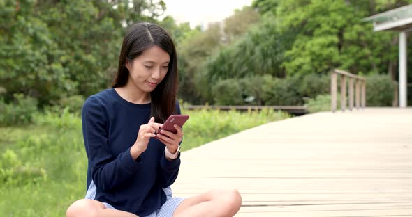 Woman use of mobile phone at outdoor park