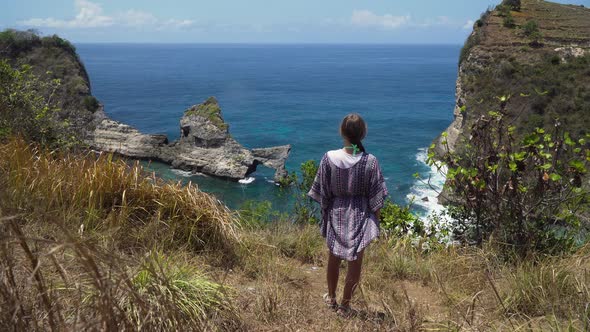 Girl Standing on a Cliff and Looking at the Sea