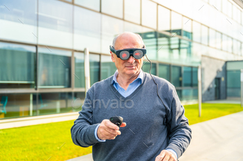 Elder businessman using an augmented reality device outdoors