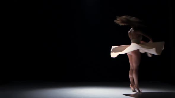 Young Woman Dancer Dancing Contemporary Dance Moves, Jumps and Makes a Split, on Black, Shadow