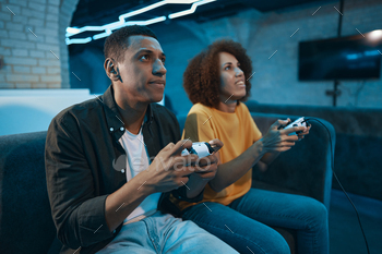 Man and woman play console and show emotions.