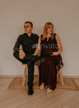 couple in love sits on chairs and looks in different directions.