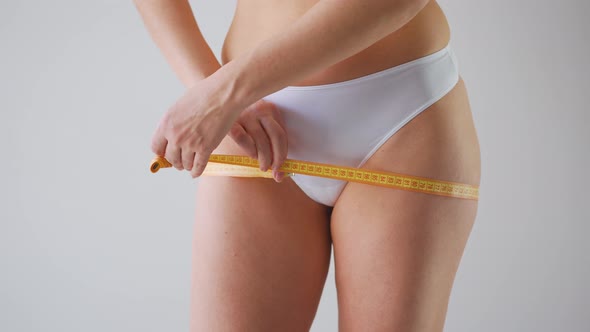 Woman Measuring Her Thighs with a Measuring Tape