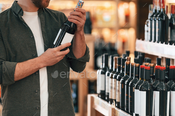 Man is choosing wine in the store