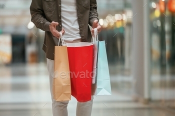 Close up view, holding shopping bags. Man is shopping in the supermarket