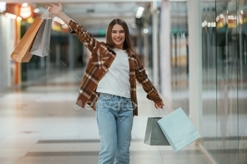 With shopping bags in hands. Woman is in the supermarket