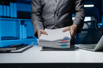 An employee held a large pile of documents in his hand, Large piles of work documents on desks are b