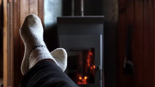 Two Pair Feet Legs in Winter Wool Socks at Fireplace Background