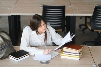 education and school concept - student girl studying and reading book at school.