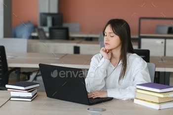 A cute schoolgirl is sitting at a desk at school. The concept of schooling.