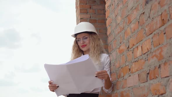 Female Architect in Business Attire Standing Outdoors at Construction Site