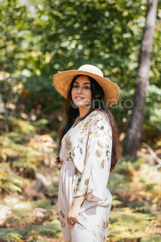 Woman with straw hat in the forest