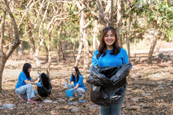 Volunteer collecting plastic trash in the forest. The concept of environmental conservation. Global