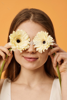 Girl Covering Eyes With Flowers