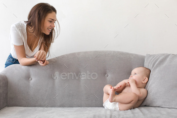 Content woman with baby on gray sofa