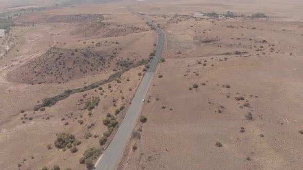 aerial shot descending to a stand still vehicle on a busy road