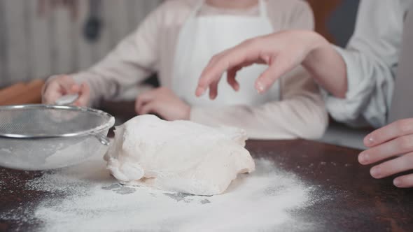 Mom And Daughter Kneading Dough Together