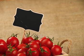 Red tomatoes in box with price sign over canvas