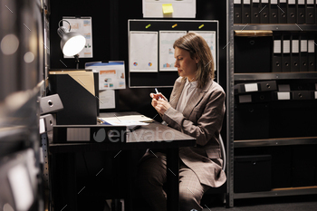 Manager sitting at desk in arhive room