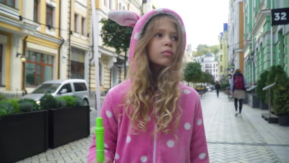 Portrait of Pretty Cute Caucasian Girl in Pink Costume Walking with Balloon Outdoors Looking Around