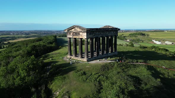 Aerial wide cinematic, camera circles as family reach the top of Penshaw Monument in Sunderland, Nor