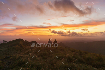 Couple in the mountain watching the sunset