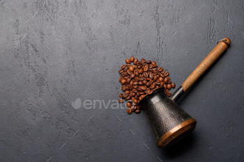 Roasted coffee beans and cezve for Turkish coffee