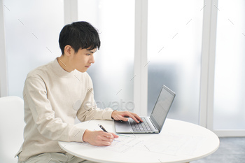 Asian man using accounting software