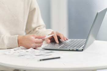 Hand of a man entering expenses into accounting software