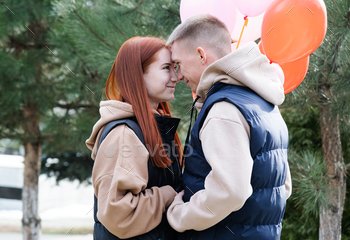 cheerful romantic couple dating outdoors with balloons