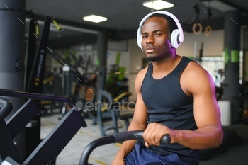 Attractive man at health club, exercising on bike