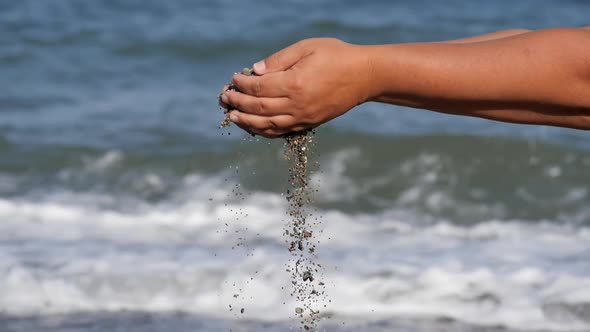 Sea Rest. A Small Shell From the Hands of the Hands Falls Down Against the Background of Raging