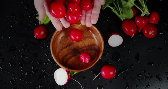 Male Hand Put Fresh Radish in a Wooden Plate. 