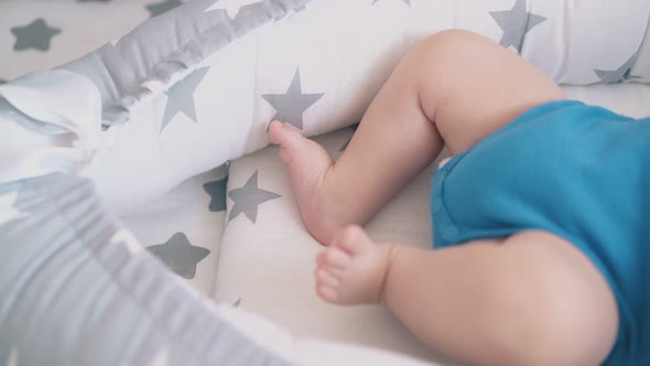 Bothering Legs of Newborn Lying in Soft Comfortable Cocoon