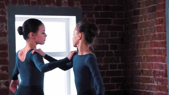 Two Ballerina Girls Dancing in Dark Dresses on Training in the Studio