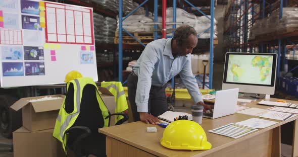 Man working at a desk in a warehouse 4k