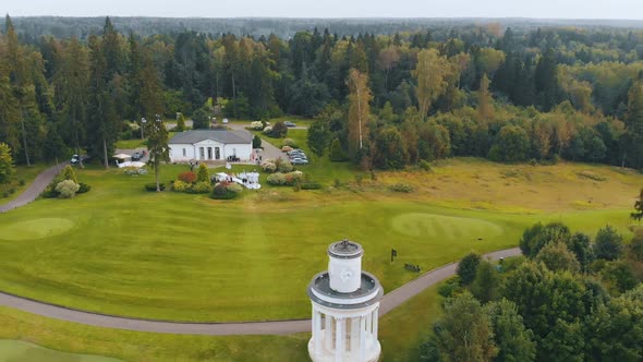 Aerial Above Park with Architectural Buildings and Tower Surrounded By Forest