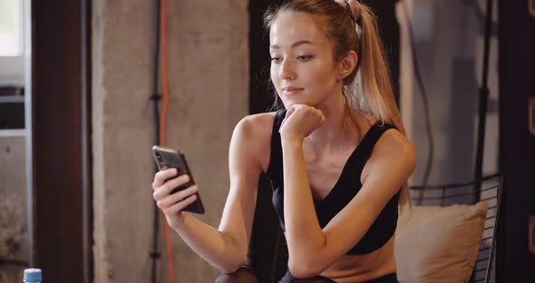 Female Athlete Using Smartphone At Gym