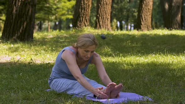 Youthful Lady Stretching in Park on Mat, Yoga Asana Amateur, Good Shape Slow-Mo